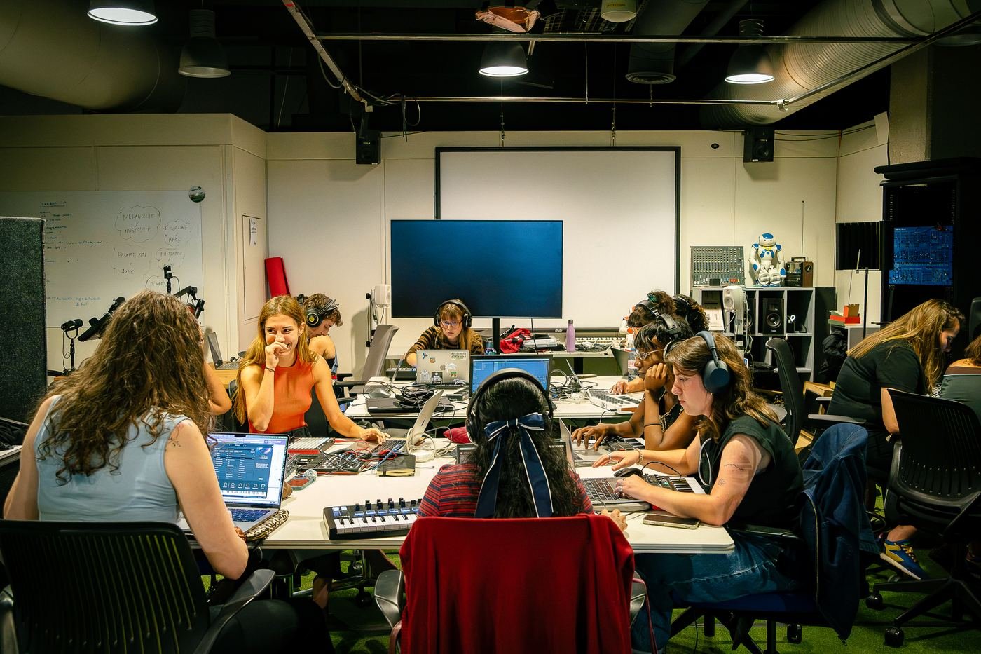 Une session DAWghters : une quinzaine de participantes produisent sur leurs ordinateurs autour de grandes tables