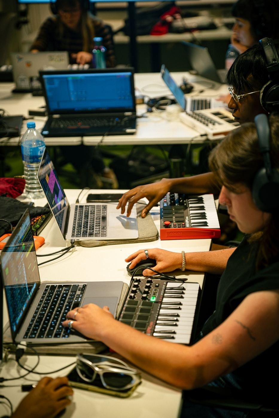 Mains sur un clavier MIDI, à côté d'un ordinateur portable